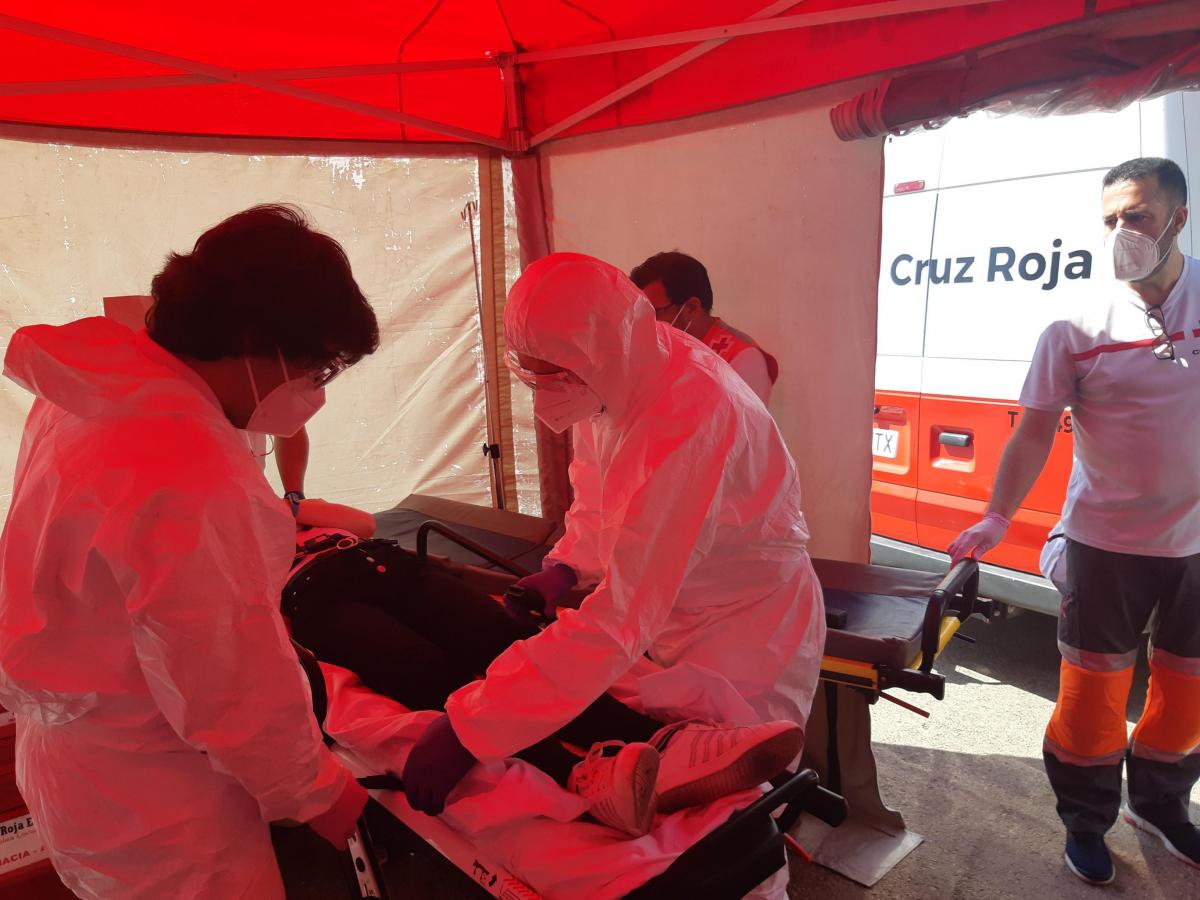 personal sanitario de cruz roja dentro de una carpa con trajes de protección