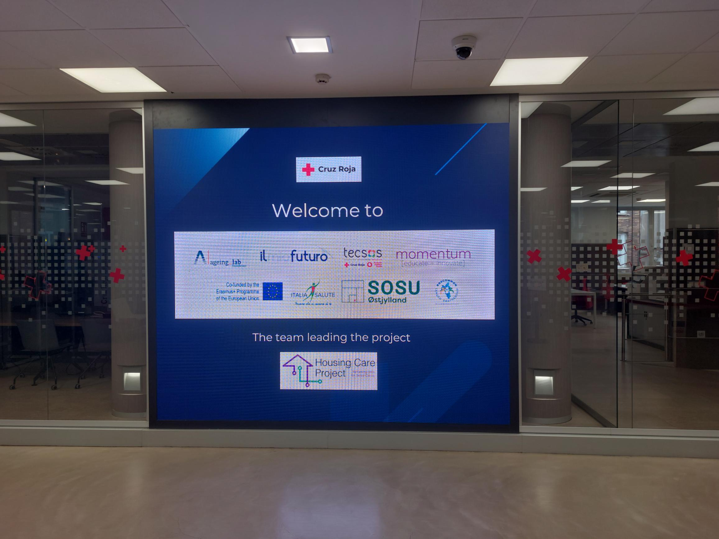 hall de la oficina central de cruz roja con una pantalla dando la bienvenida a los socios europeos