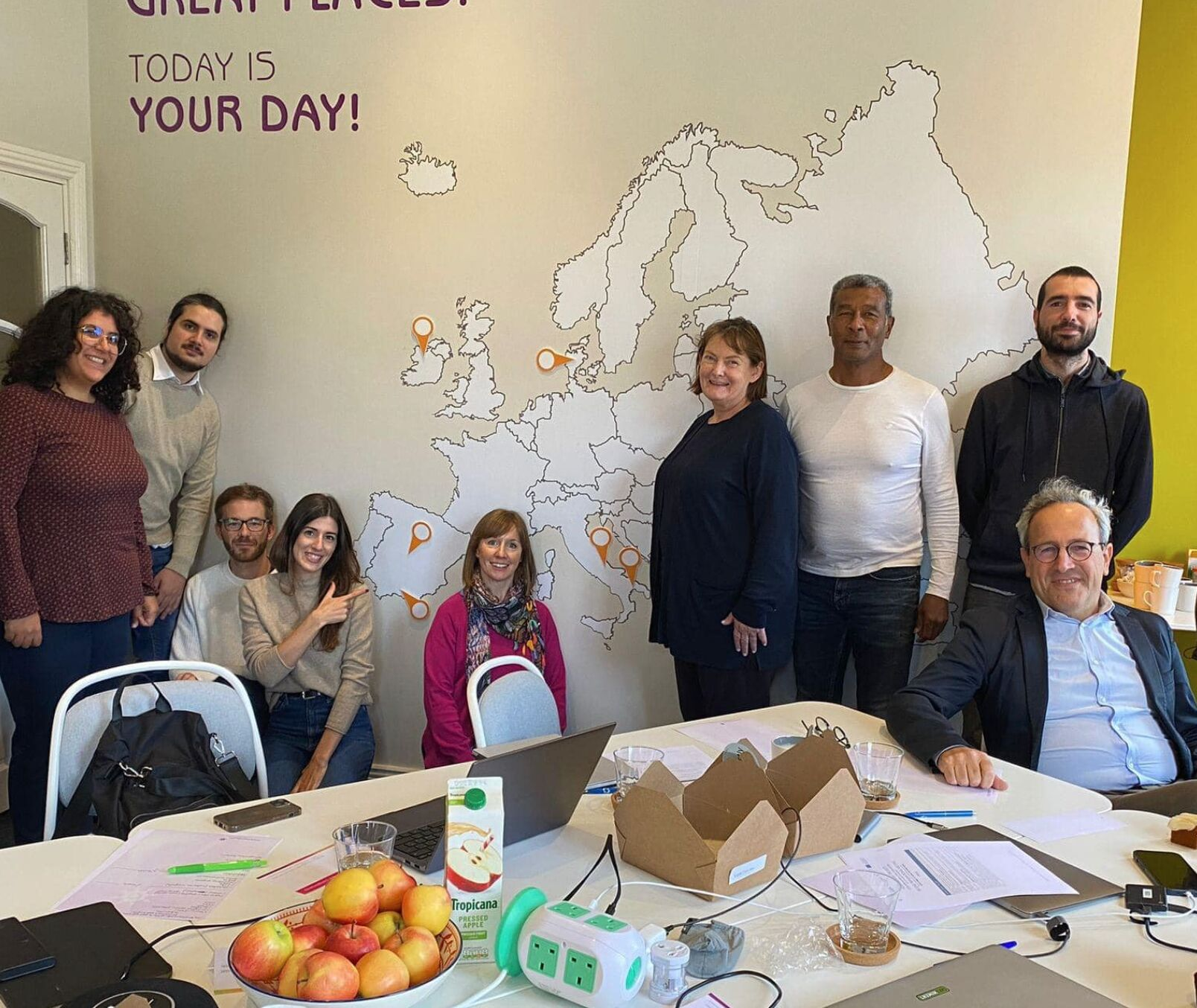 equipo de housing care reunido en irlanda posando, en el fondo un mapa de europa en la pared