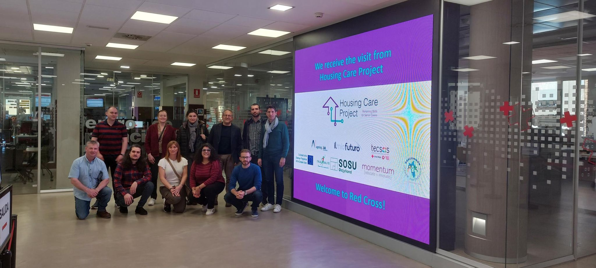 equipo de housing care posando en el hall de la oficina central de cruz roja española y tecsos